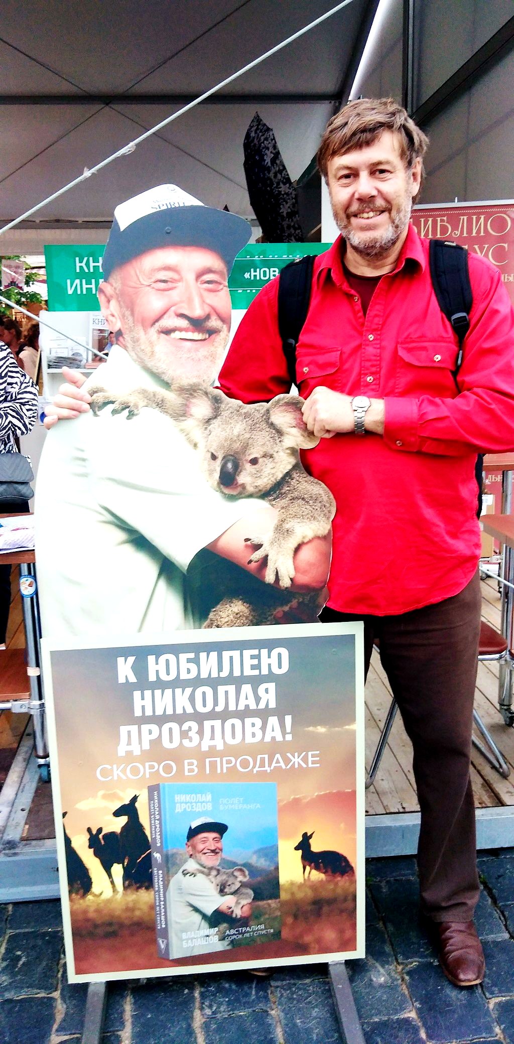 Владимир Балашов на презентации книги Полёт бумеранга, баннер с Николаем Дроздовым